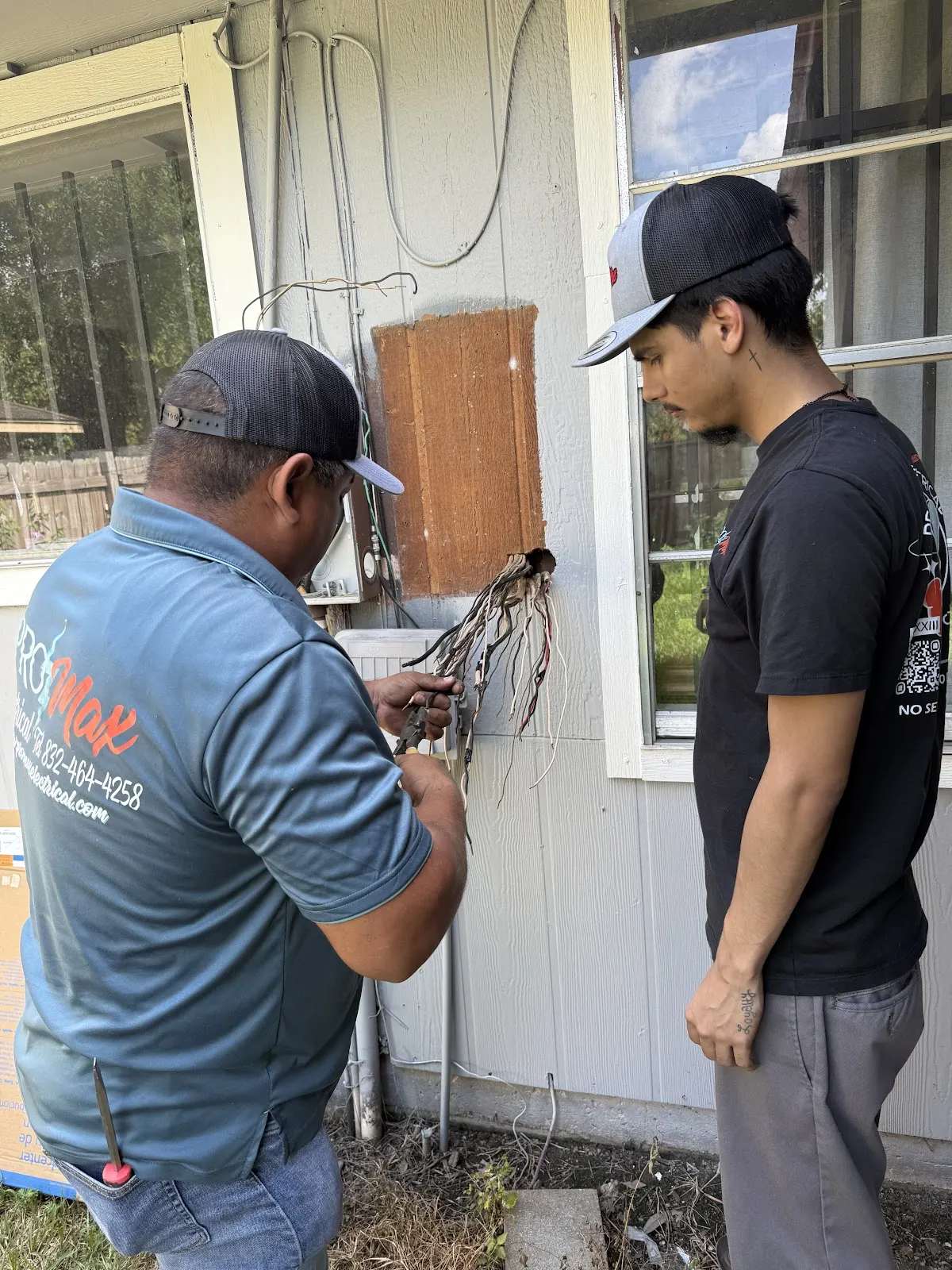 Two Pro Max Electrical technicians working at an electric meter