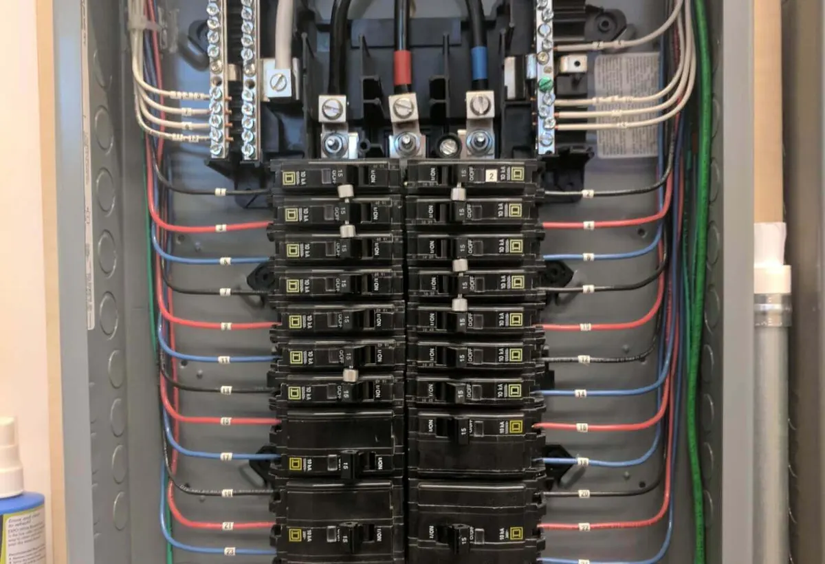 Open residential breaker panel with breakers and wiring, worked on by Pro Max Electrical