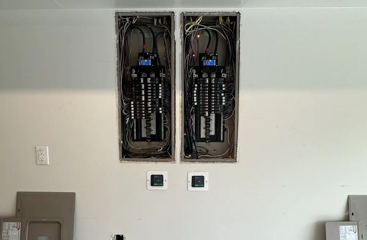 Two new breaker panels installed side by side on an interior wall by Pro Max Electrical