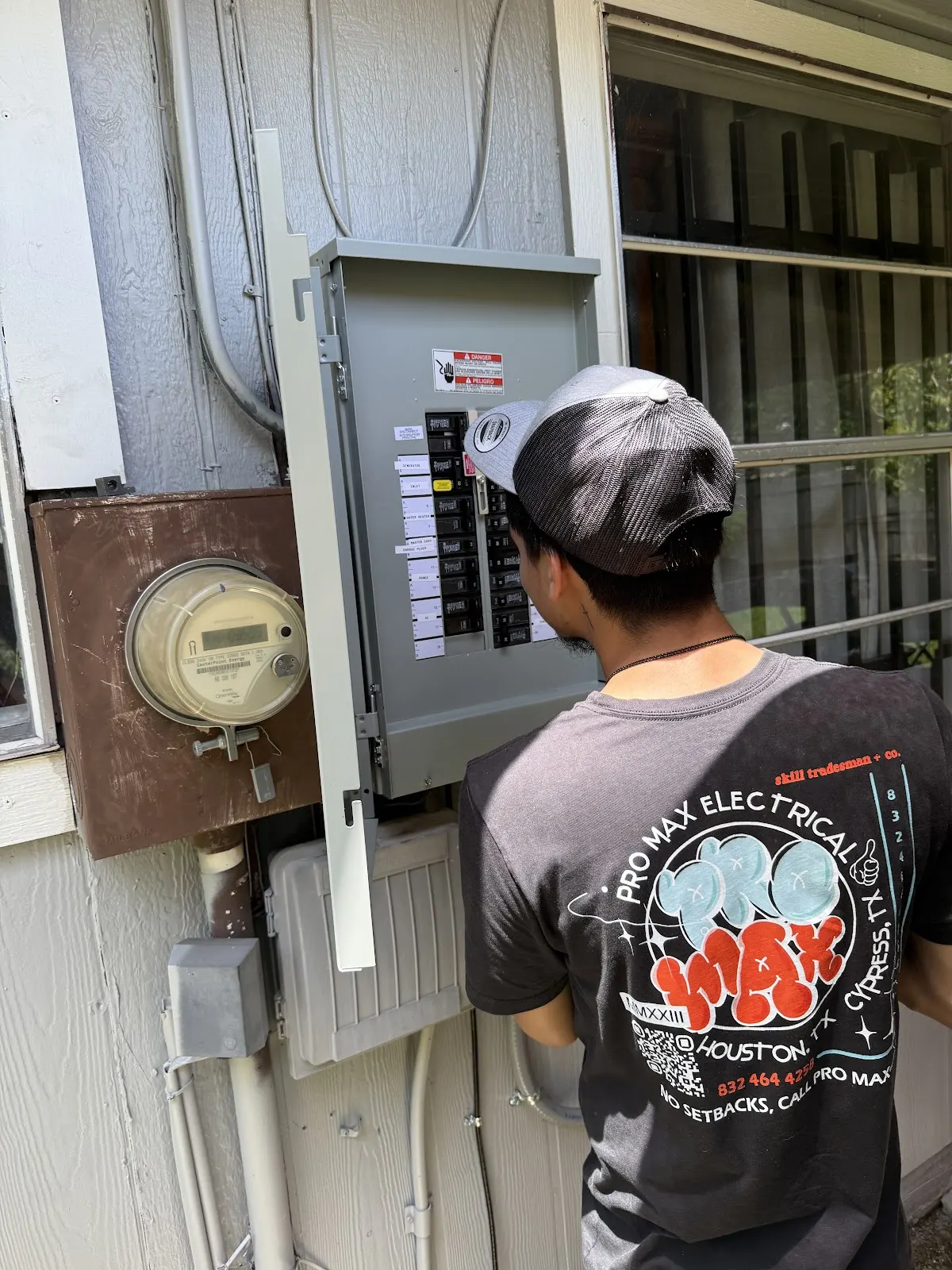 Pro Max Electrical technician working at an outdoor breaker panel next to the meter