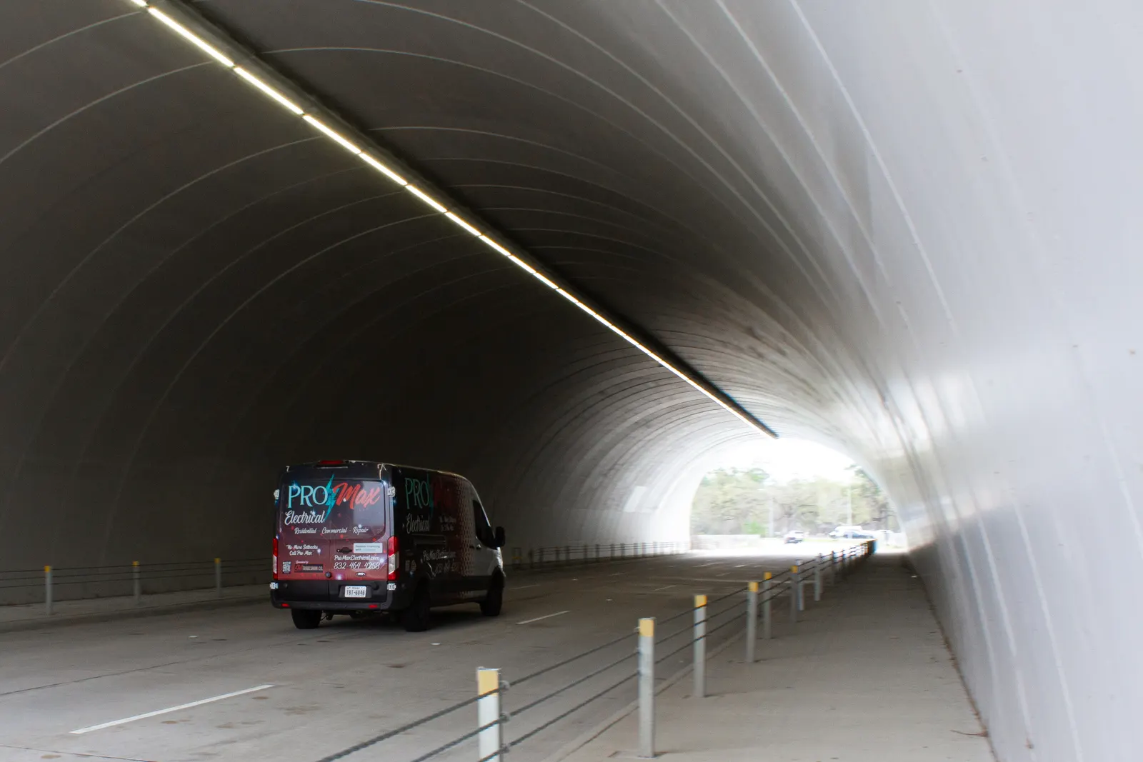 Pro Max Electrical van driving through a concrete tunnel